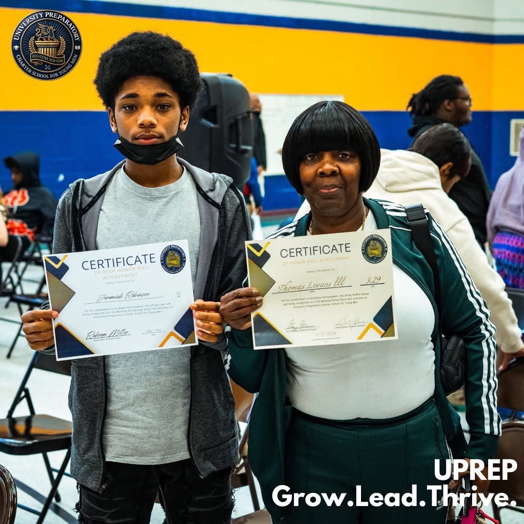 A UPrep student and his mother holding his honor roll certificate