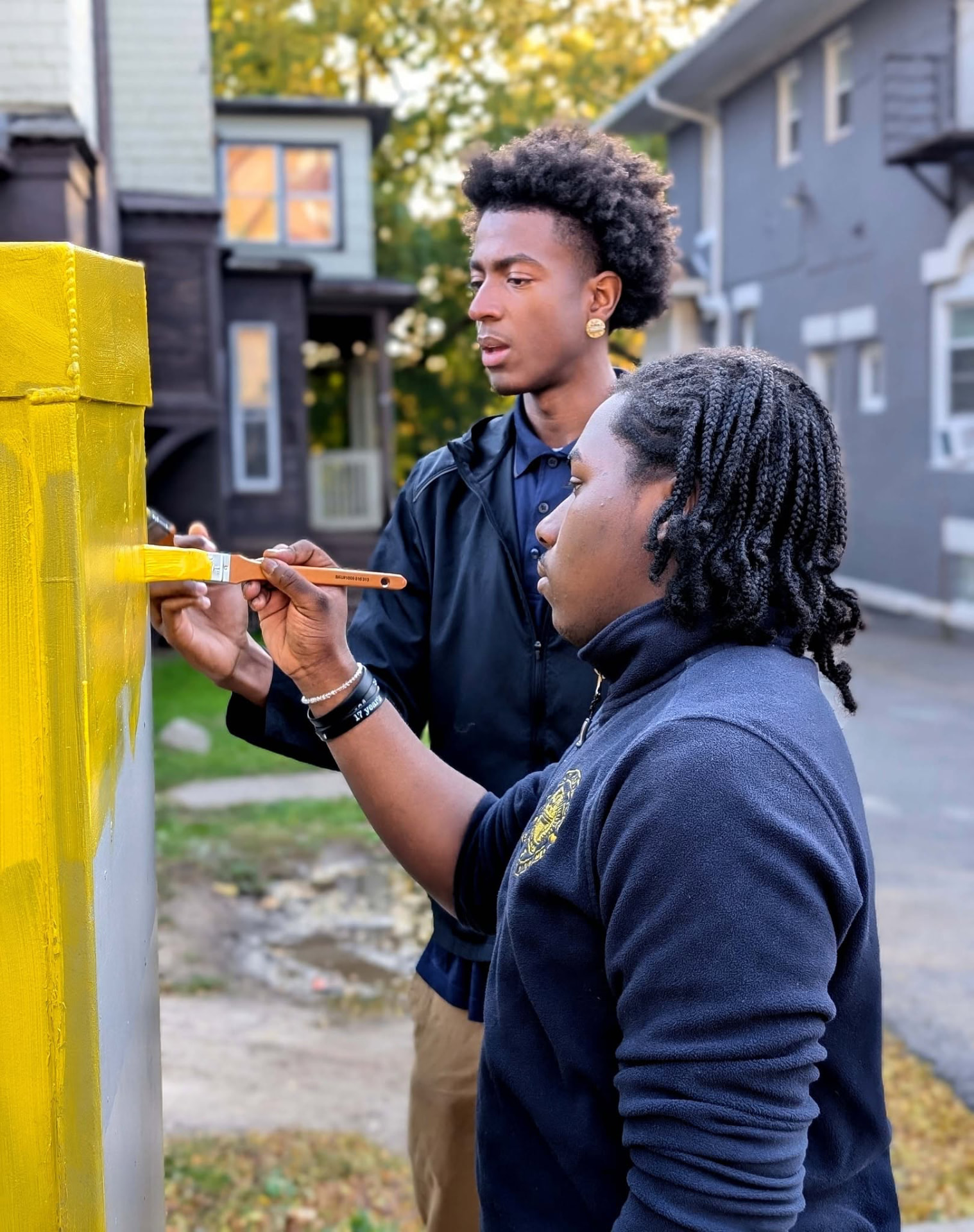 UPrep students painting a community structure bright yellow