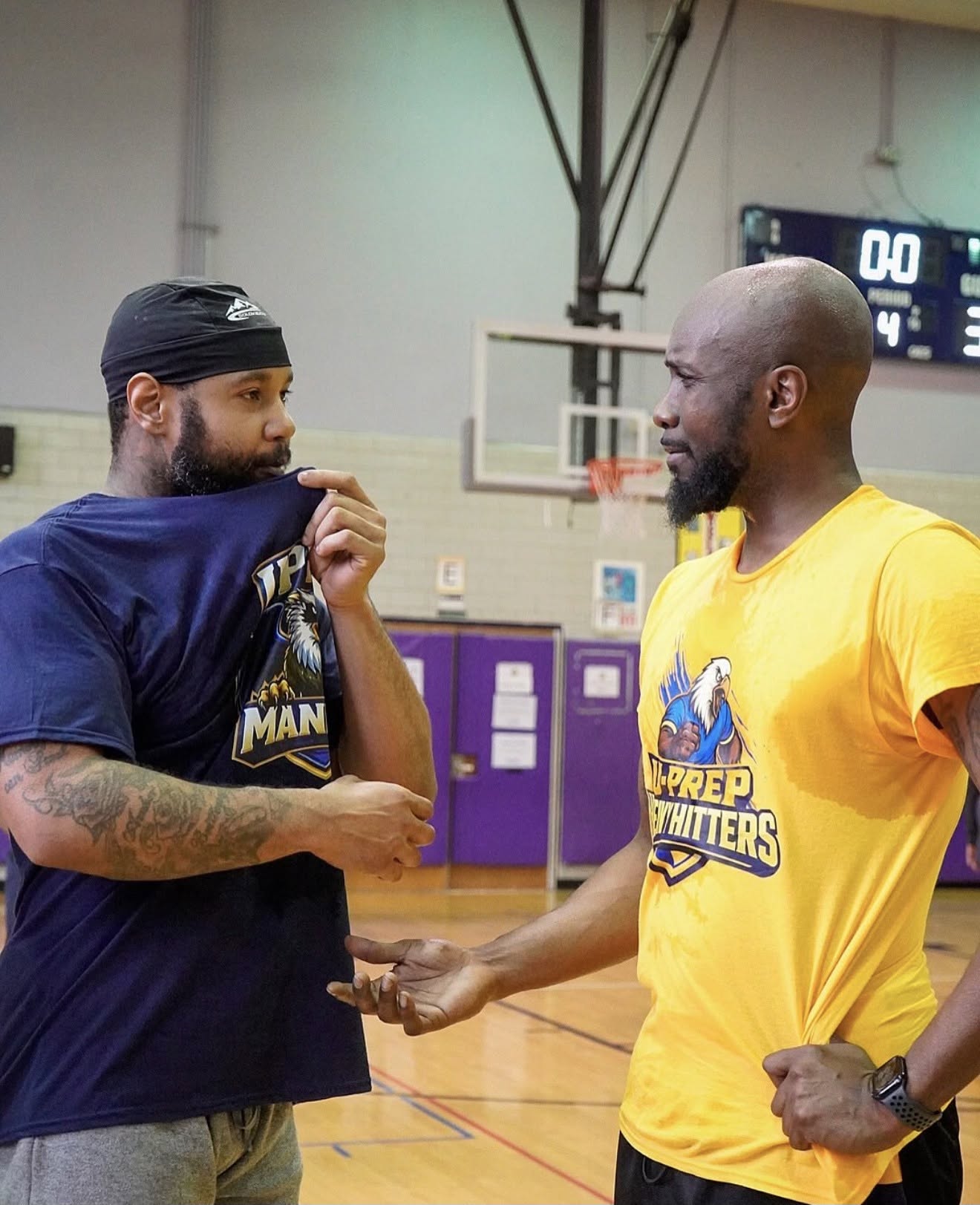 Two UPrep staff members talking one-on-one in the gym