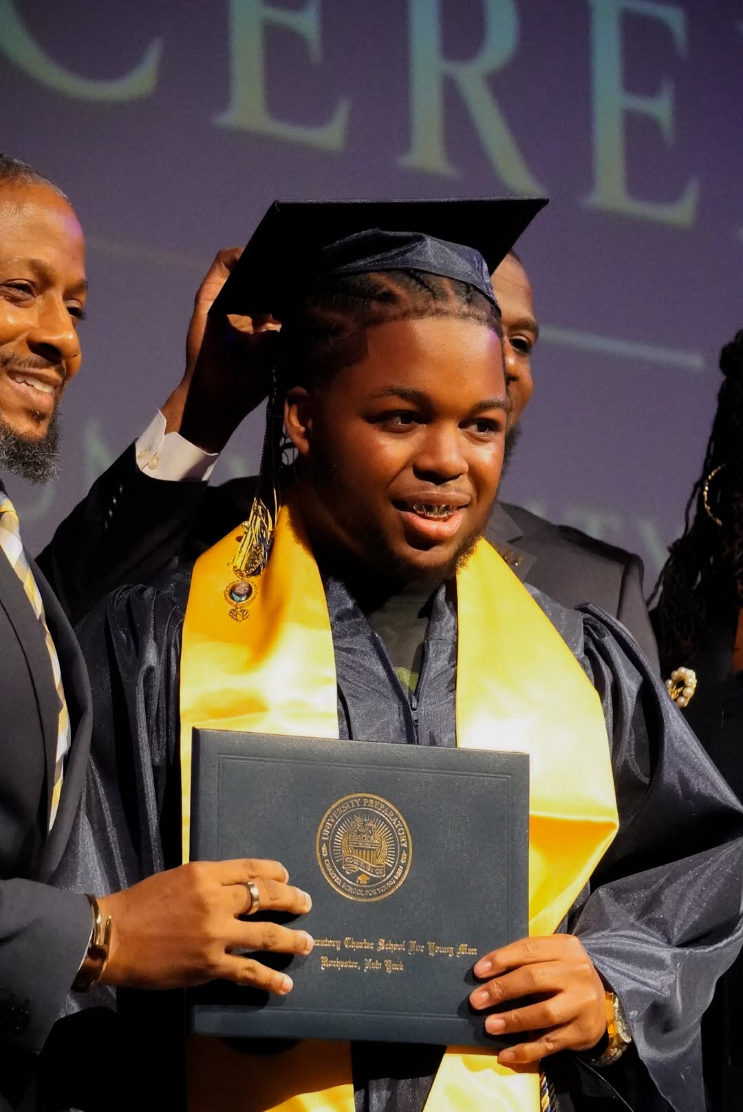 A UPrep graduate having his cap tassel turned on stage