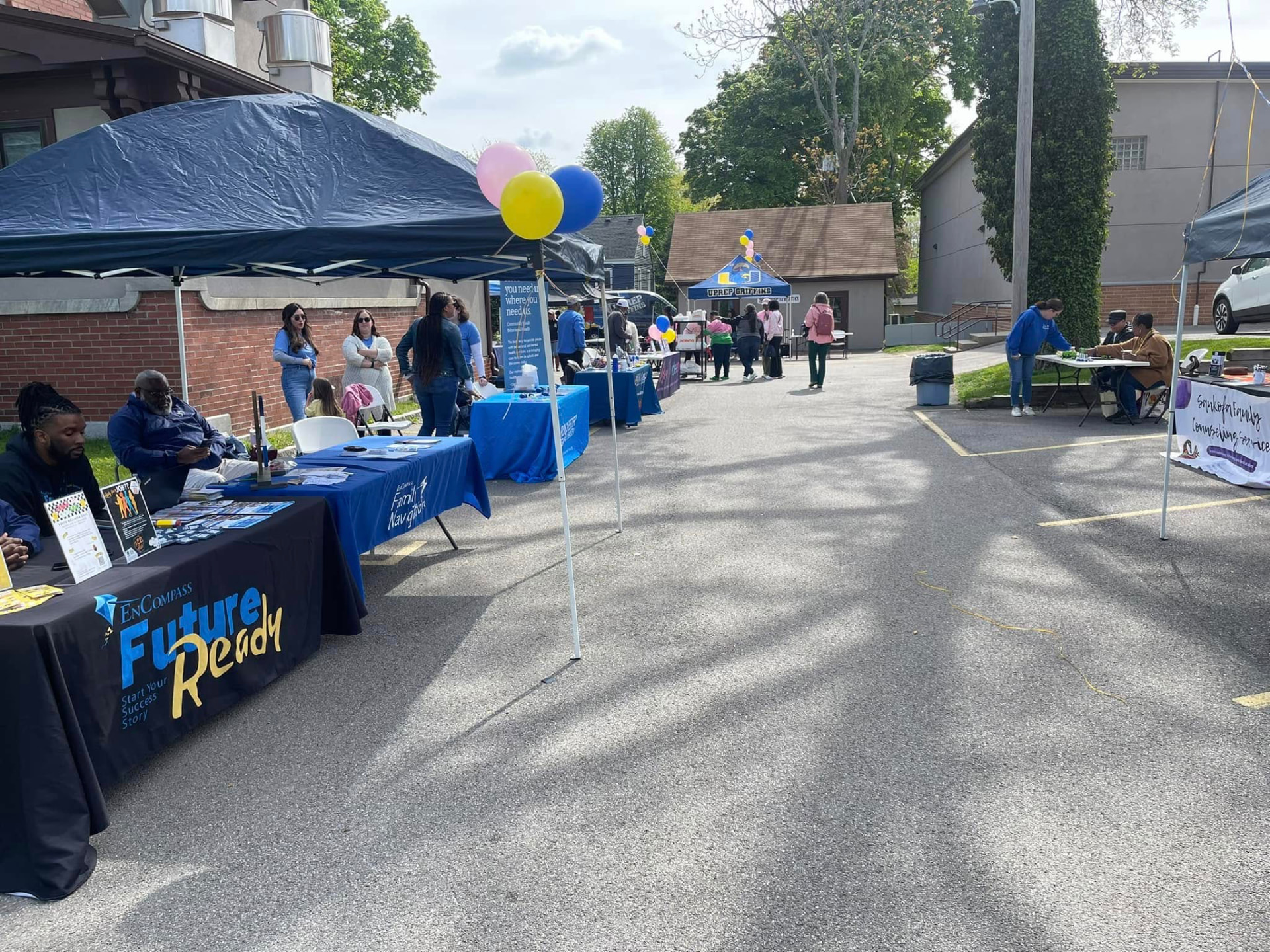 UPrep families and staff at an outdoor community resource fair with the Griffins tent