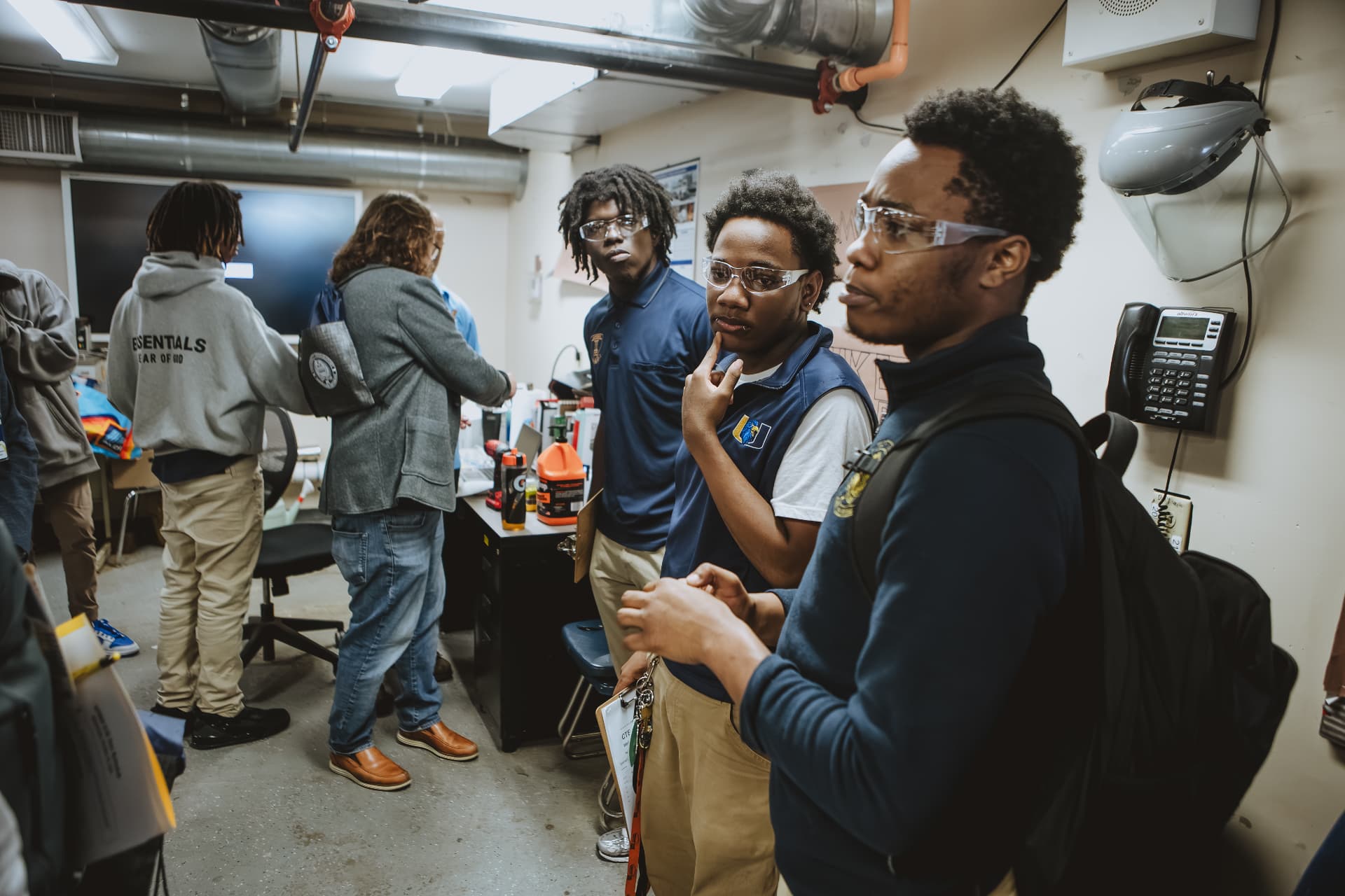 Three UPrep students wearing safety glasses in a career and technical education shop