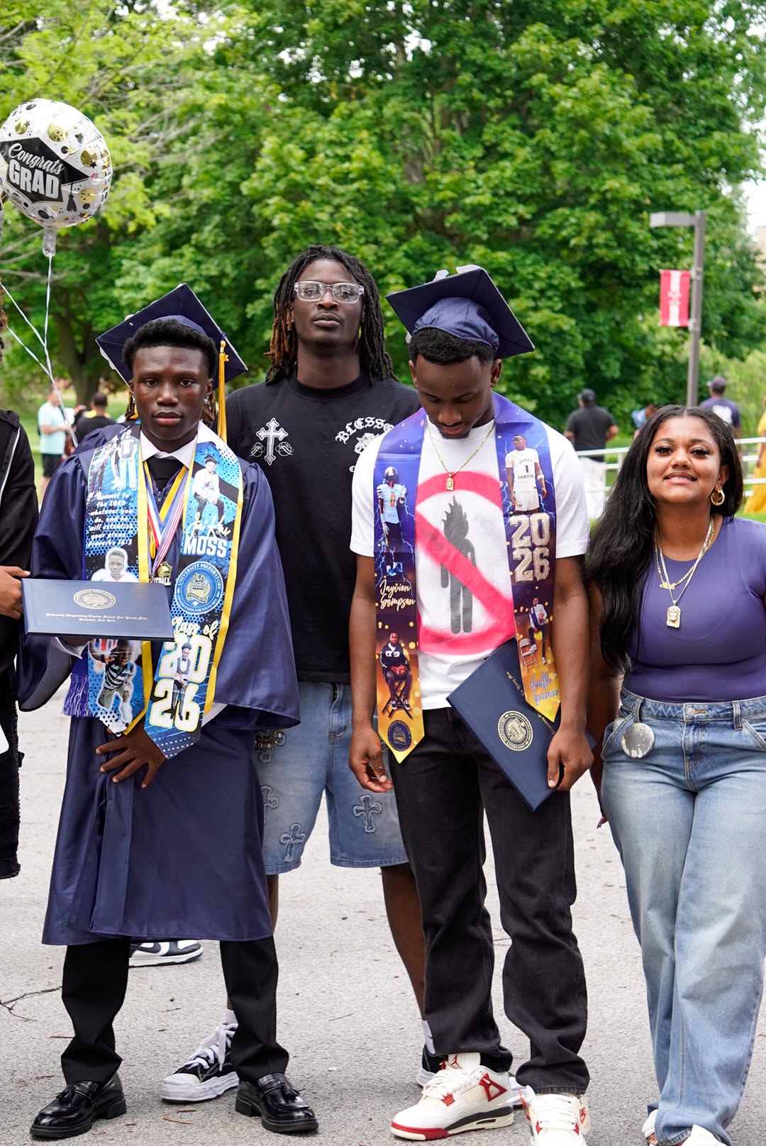 UPrep graduates outside with family members and a congratulations balloon