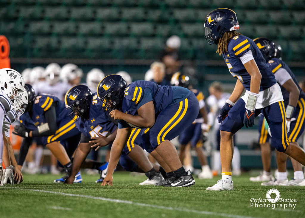 UPrep football linemen set at the line of scrimmage during a night game