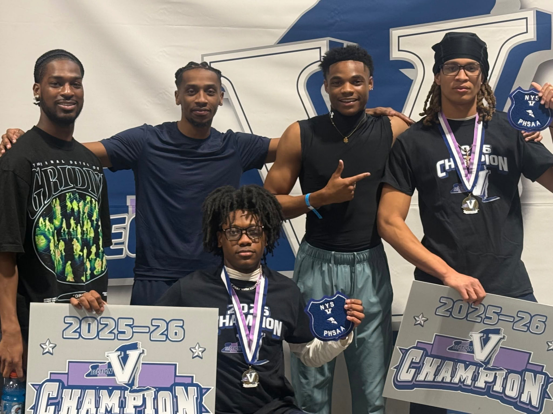 UPrep basketball players holding Section V Champion signs and medals